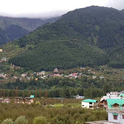 opening-window-from-hotel-seen-greenery-of-himalaya-and-village-below-the-mountain-and-hills-in-manali-india